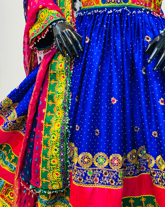 Colorful traditional outfit with a blue skirt and red and green patterns.