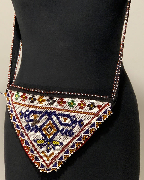 Beaded handbag on a mannequin against a neutral background