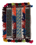 Colorful kilim rug with geometric patterns and tassels on a white background