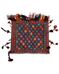 Colorful kilim rug with geometric pattern and tassels on a white background