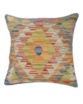 Multicolored geometric patterned pillow on a white background