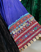 Colorful embroidered fabric with patterns and coins on a dark background