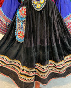 Traditional embroidered garment with black fabric and colorful patterns.