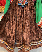 Brown velvet garment with colorful embroidery on a textured surface