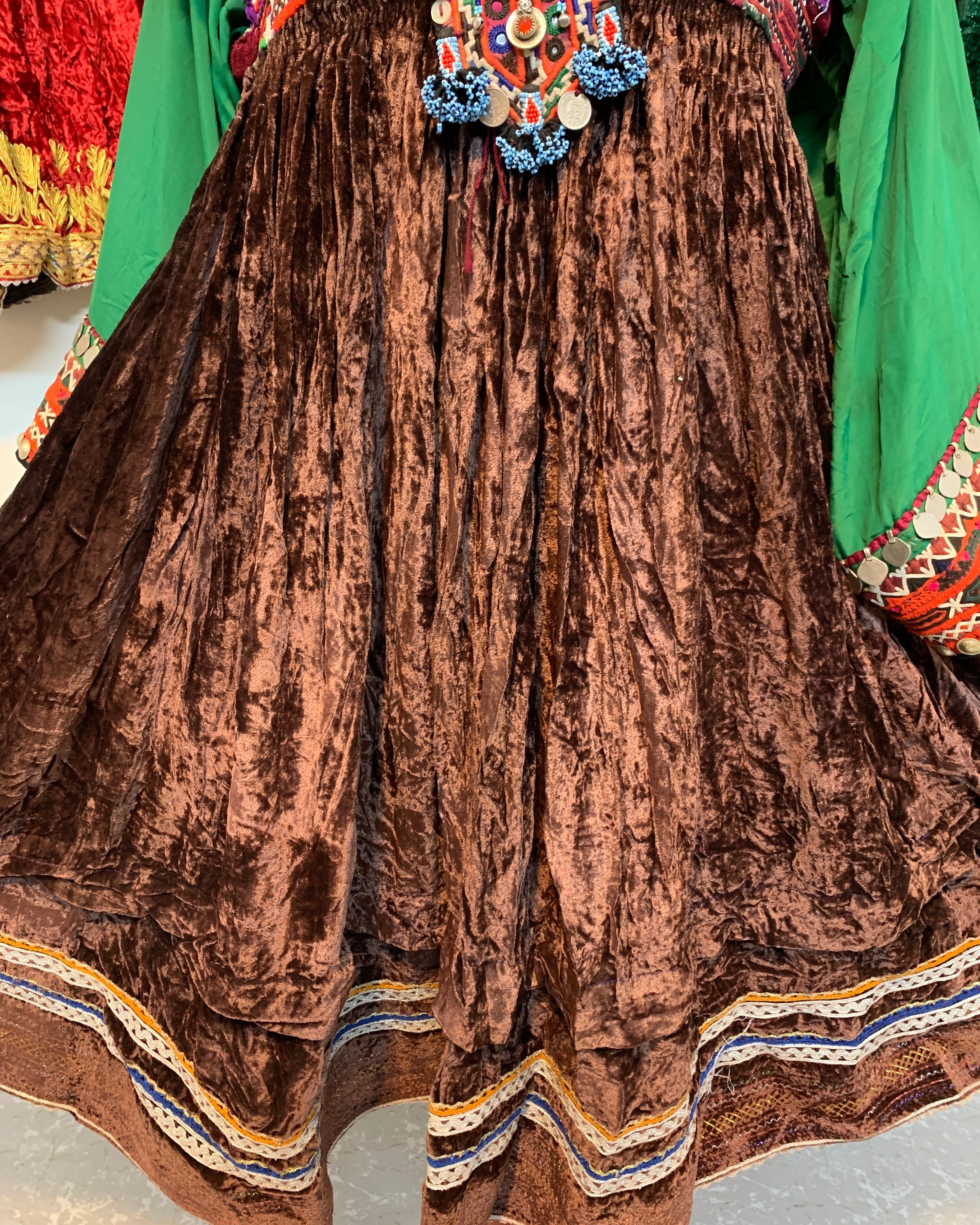 Brown velvet garment with colorful embroidery on a textured surface
