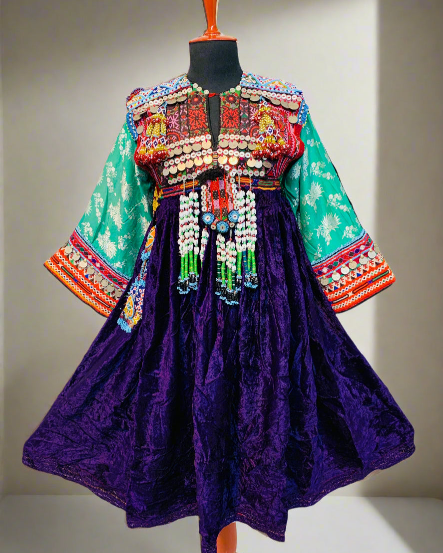 Colorful traditional dress with intricate patterns on a mannequin against a neutral background