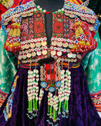 Colorful embroidered garment with intricate patterns and beadwork on a mannequin.