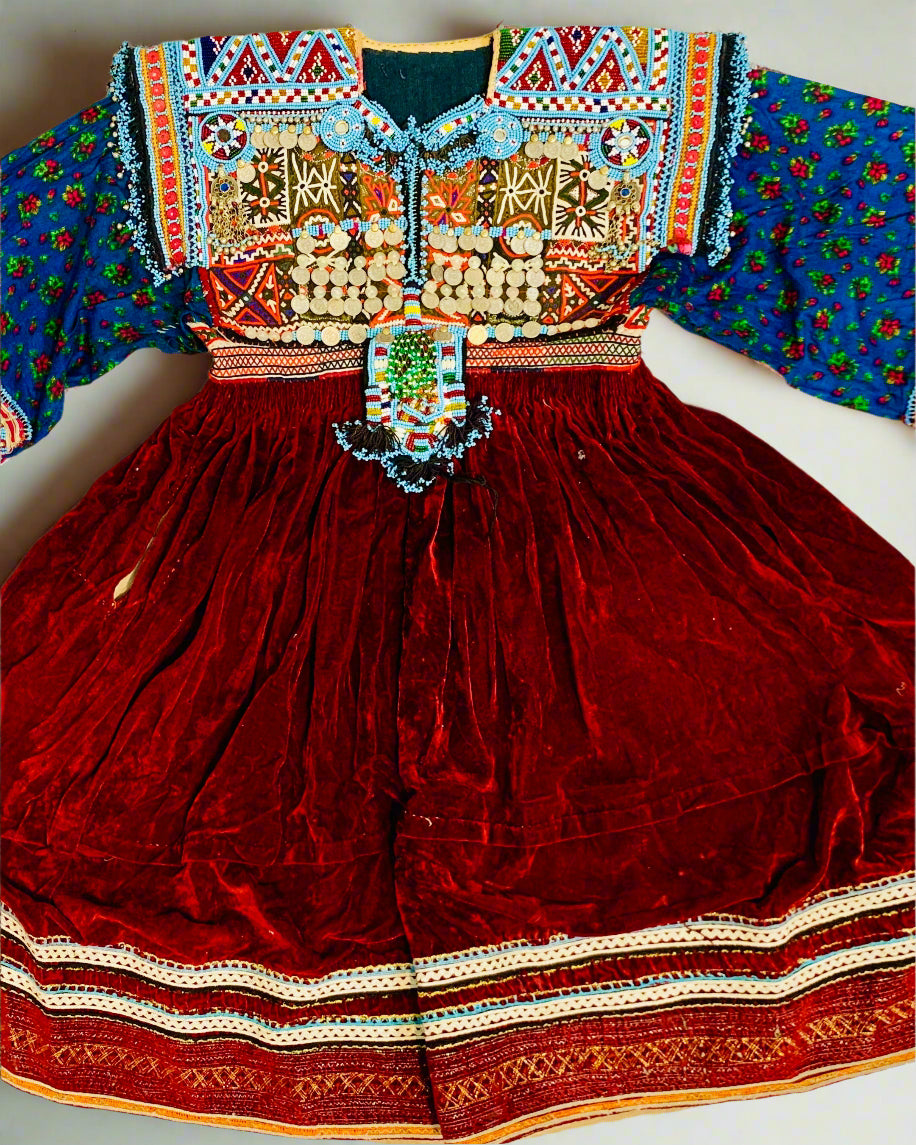 Traditional embroidered dress with colorful top and red skirt on a white background