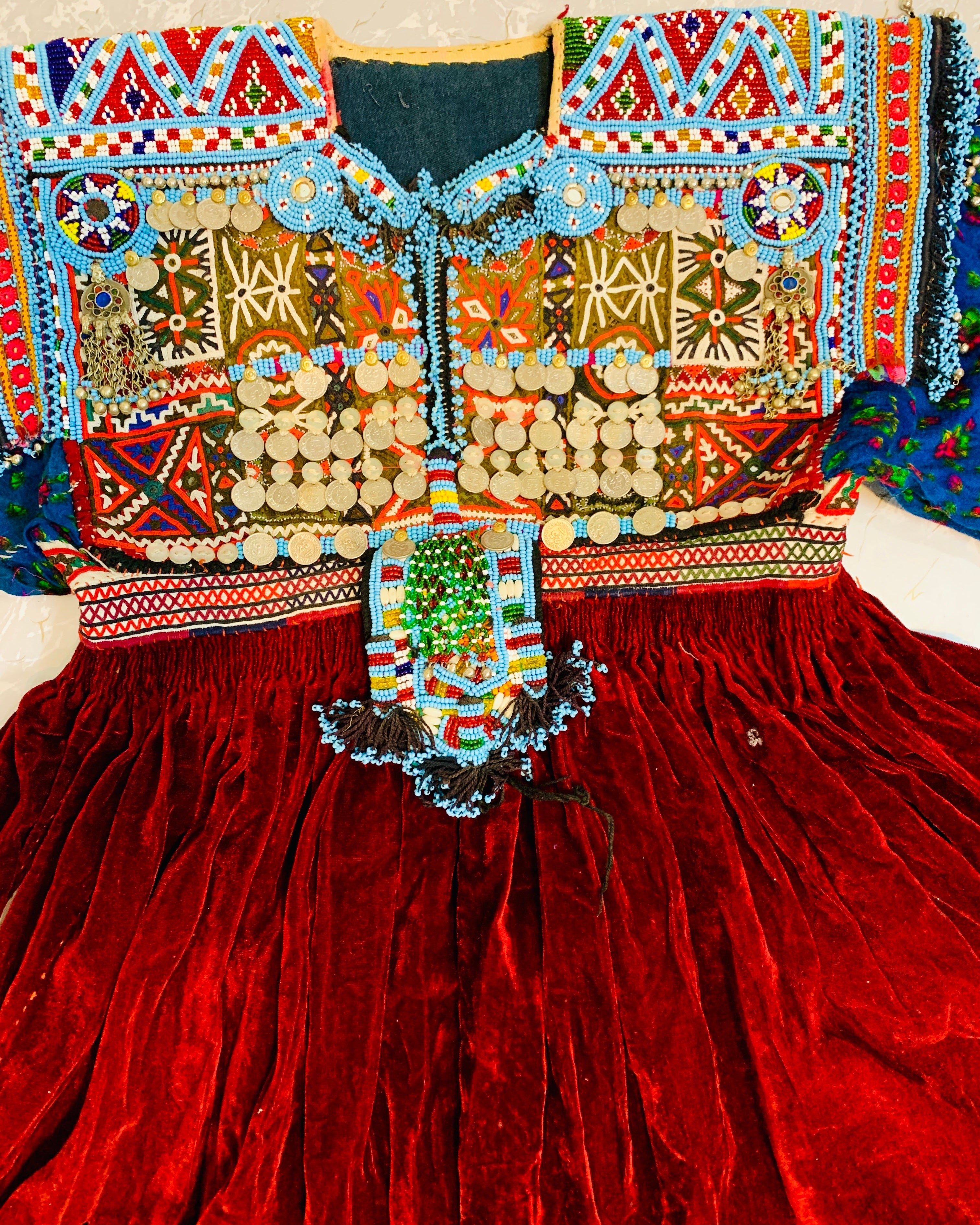 Colorful embroidered garment with intricate patterns on a red fabric background