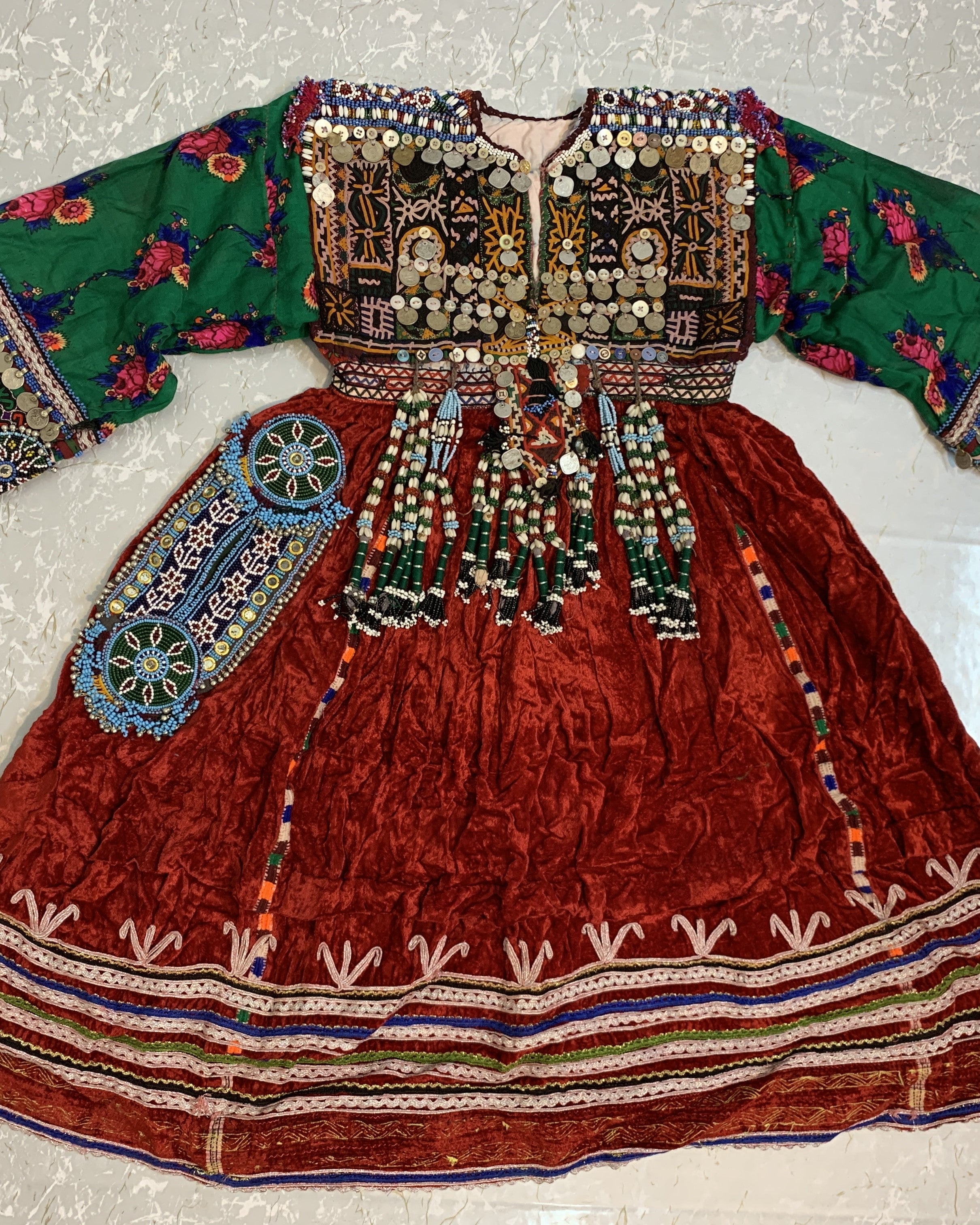 Traditional embroidered dress with colorful patterns on a textured surface