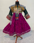 Traditional embroidered outfit on a mannequin against a textured white background