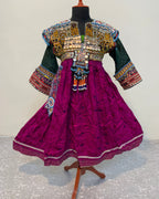 Traditional embroidered outfit on a mannequin against a textured white background
