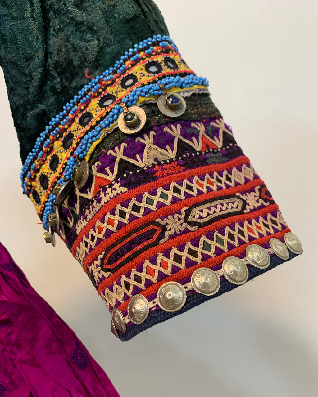 Colorful embroidered fabric with patterns and buttons on a white background