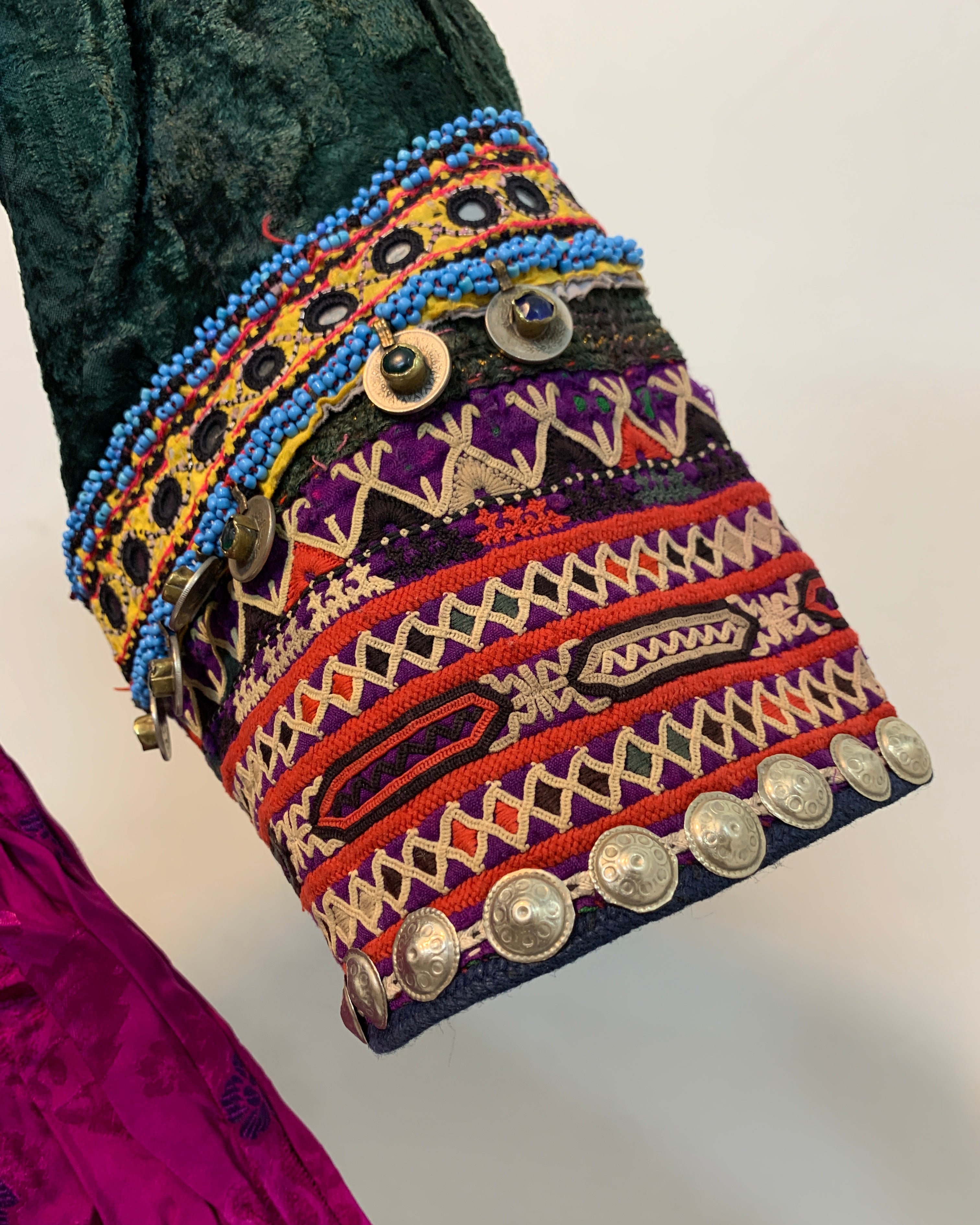 Colorful embroidered fabric with patterns and buttons on a white background