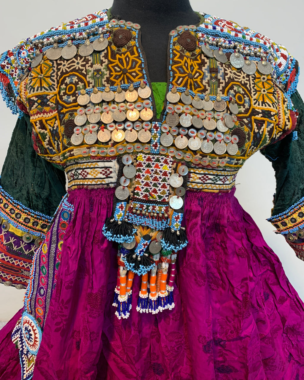 Colorful traditional outfit with intricate patterns and embellishments on a plain background