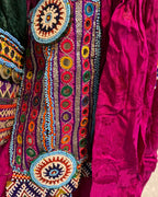 Colorful embroidered fabric with intricate patterns on a pink background