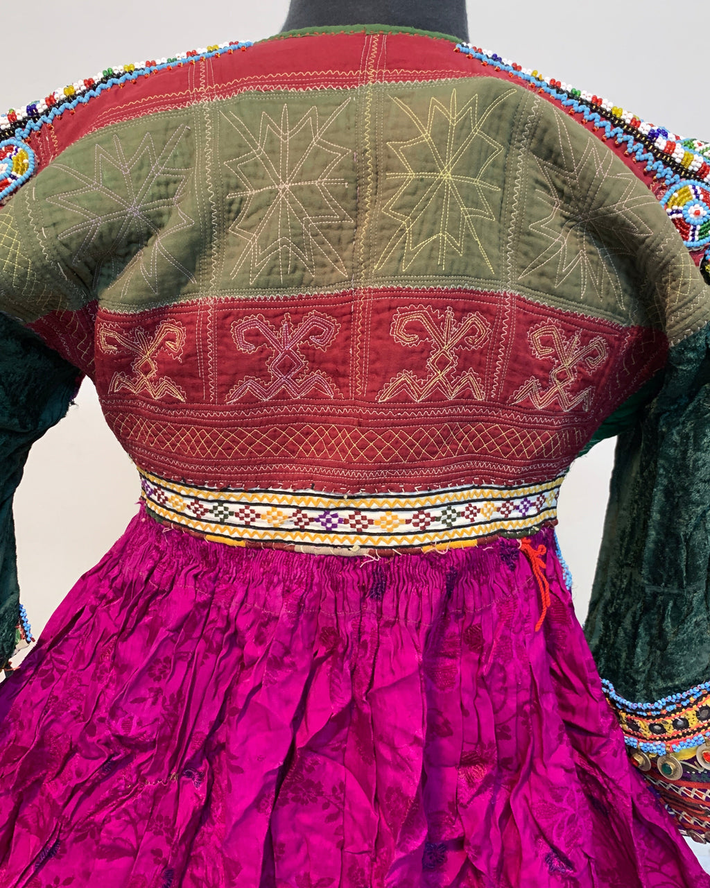 Traditional embroidered garment with intricate patterns on a plain background