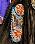 Decorative traditional garment with beadwork and embroidery on a dark fabric background