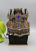 Decorative black box with intricate jewelry and gemstone embellishments on a wooden surface.