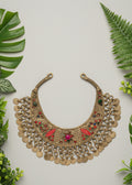 Decorative gold necklace with colorful stones on a brown fabric background