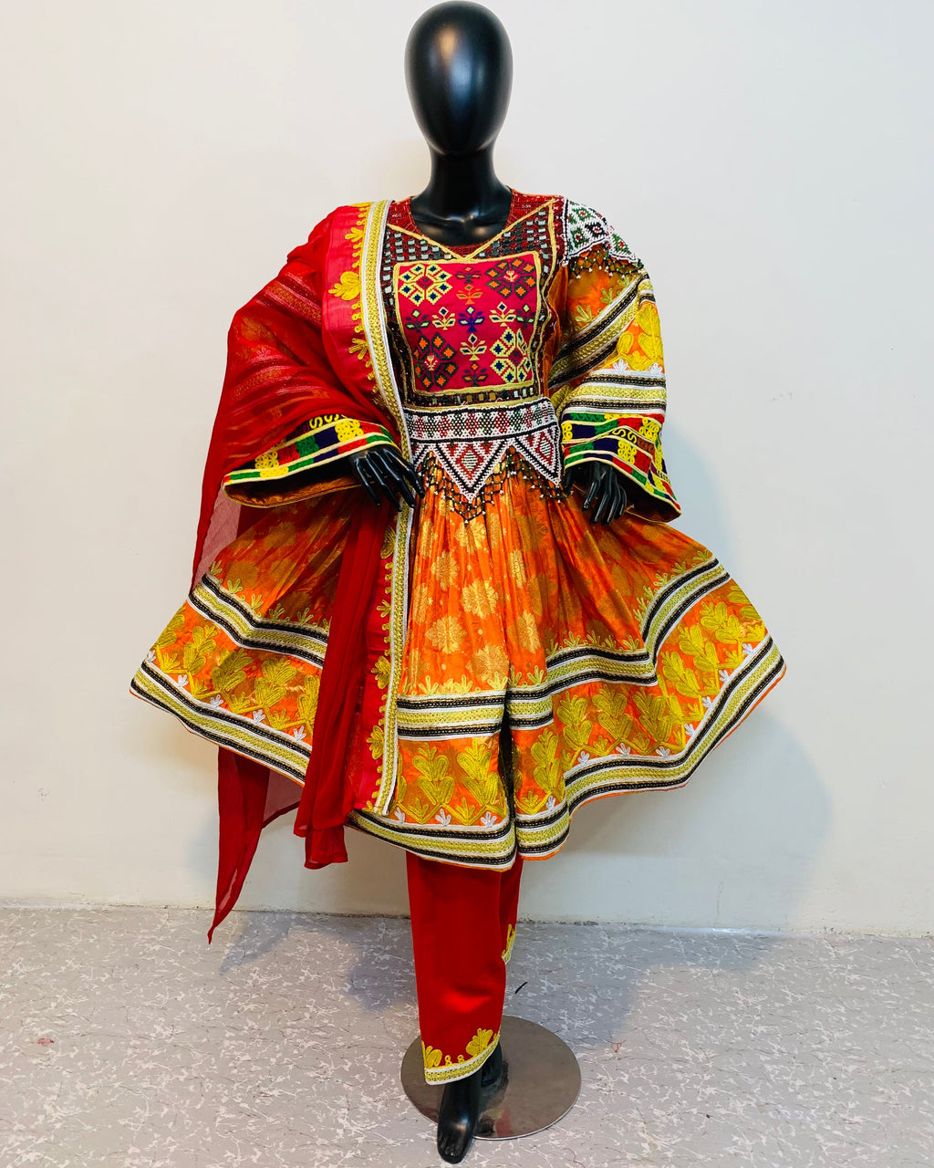 Colorful traditional outfit on a mannequin against a white background