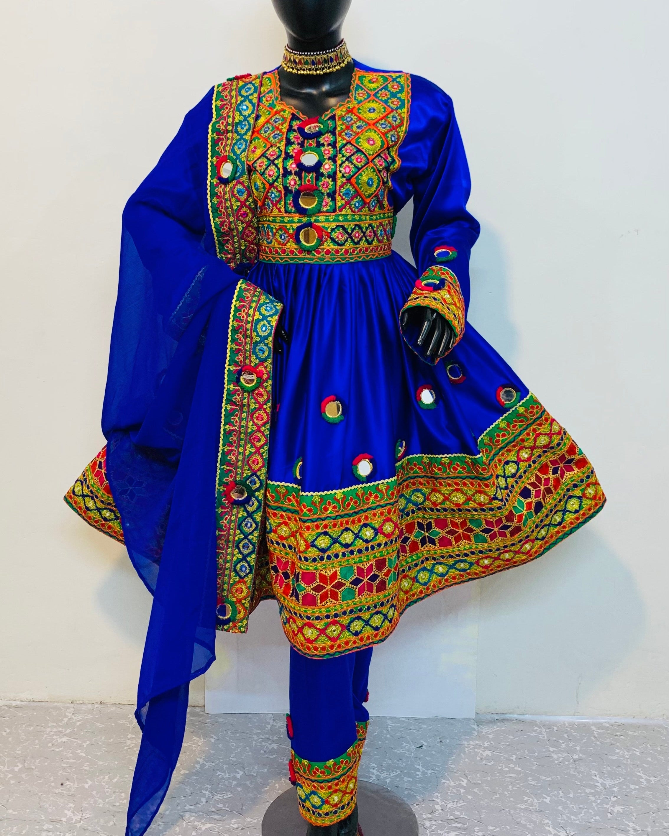 Traditional blue outfit with colorful embroidery on a mannequin against a white background