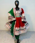 Traditional outfit with a red and green dress on a mannequin against a plain background