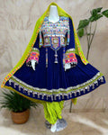 Colorful traditional outfit with a blue dress and green dupatta on a mannequin against a background of other colorful garments.