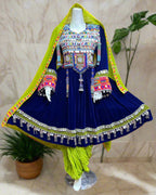Colorful traditional outfit with a blue dress and green dupatta on a mannequin against a background of other colorful garments.