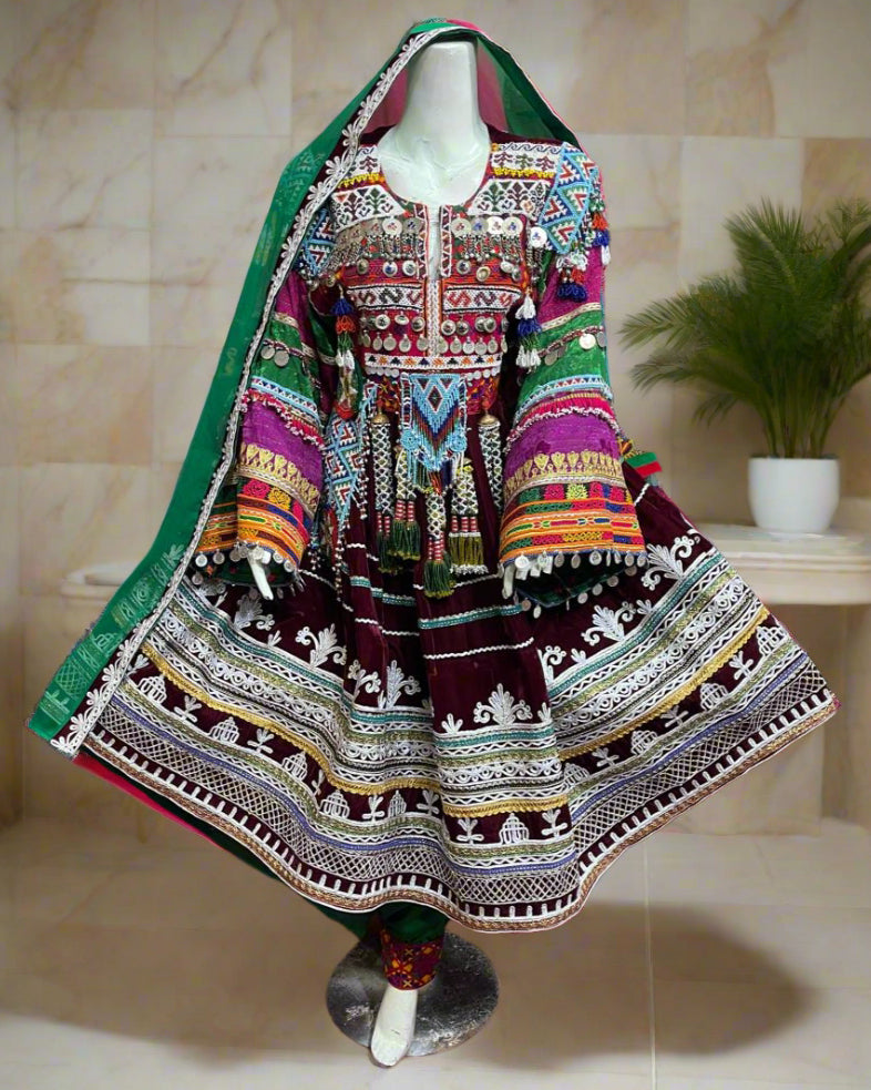 Colorful traditional dress on a mannequin with a vibrant background of various garments.