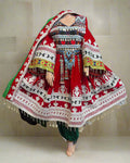 Traditional embroidered dress with intricate patterns on a mannequin against a colorful background.
