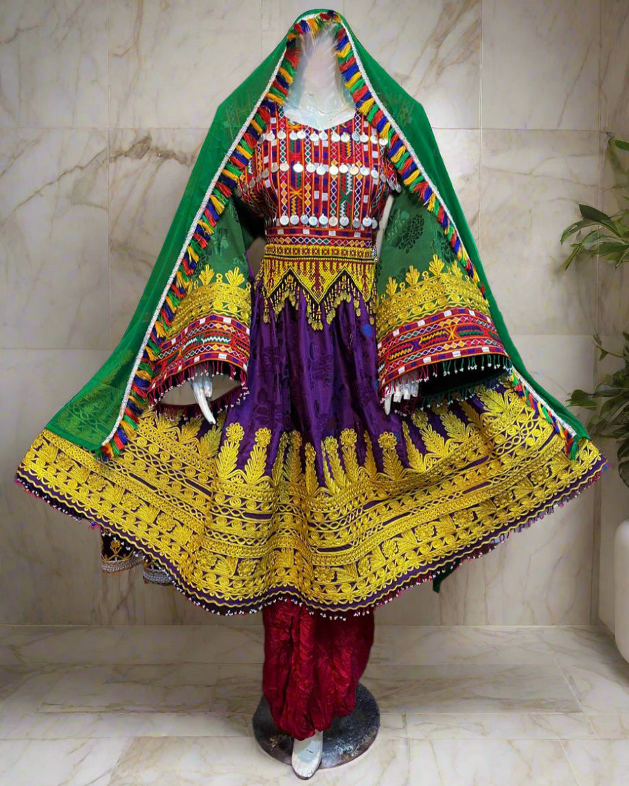 Colorful traditional dress with intricate patterns on a mannequin against a vibrant background.
