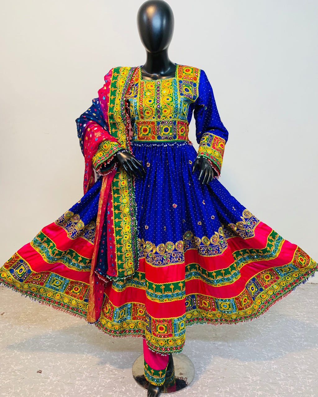 Colorful traditional dress on a mannequin against a plain background
