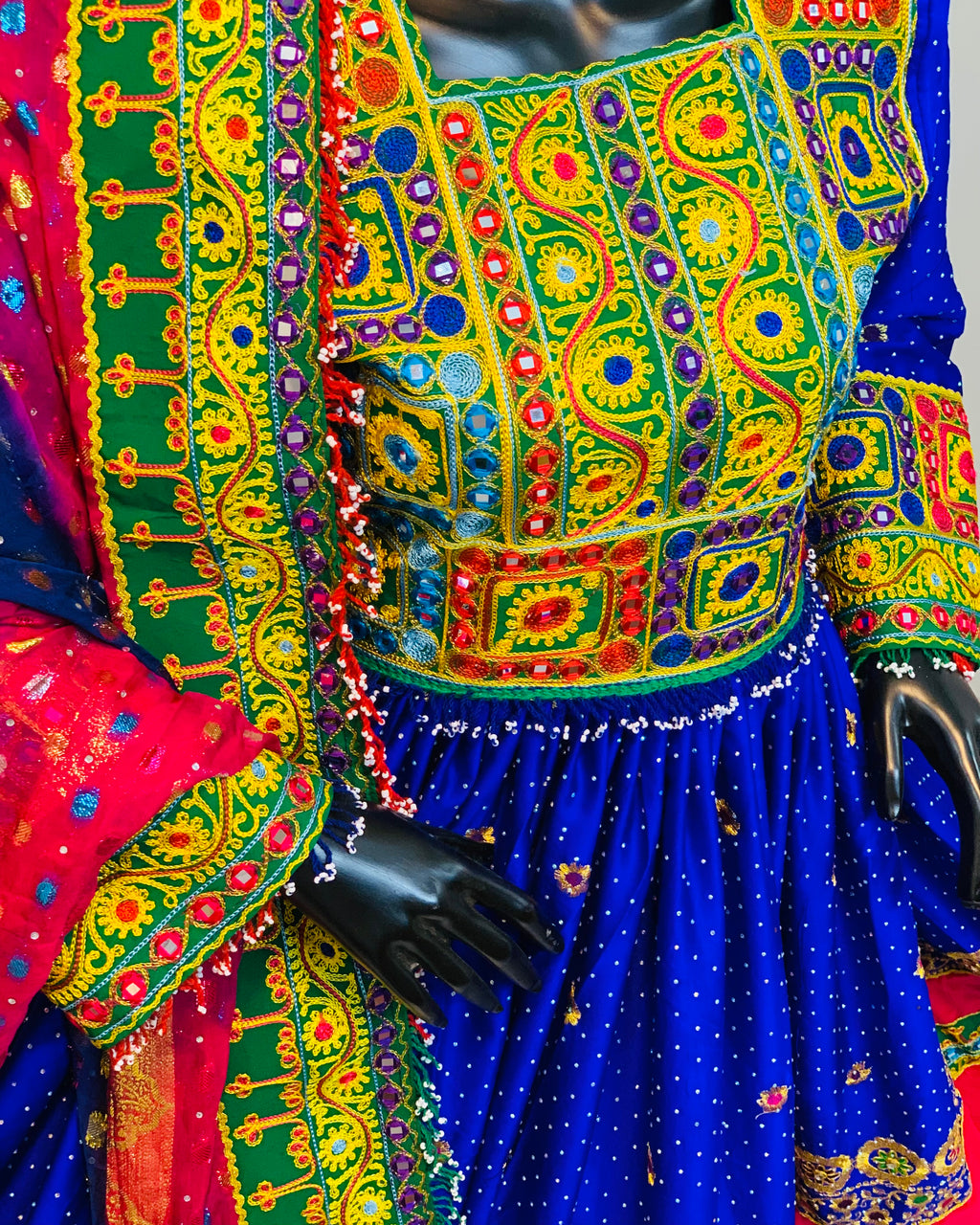 Colorful traditional outfit with intricate patterns on a mannequin.
