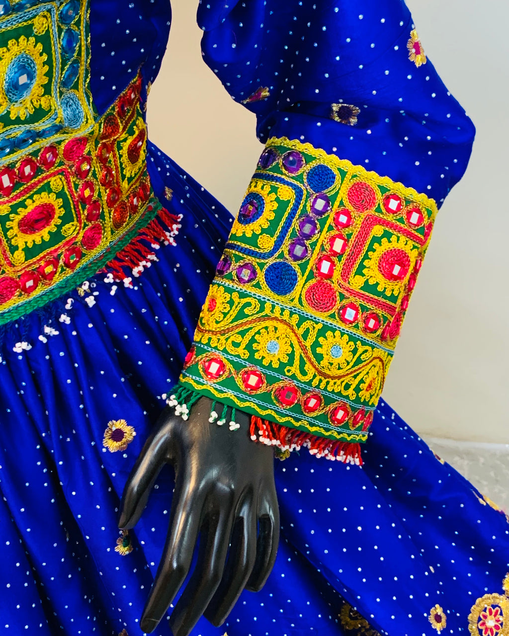 Colorful embroidered sleeve with intricate patterns on a blue fabric background