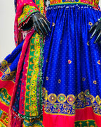 Colorful traditional outfit with a blue skirt and red and green patterns.