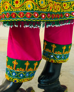 Colorful traditional outfit with embroidery and bright colors on a wooden floor.