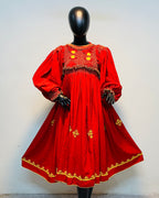 Red embroidered dress on a mannequin against a white background